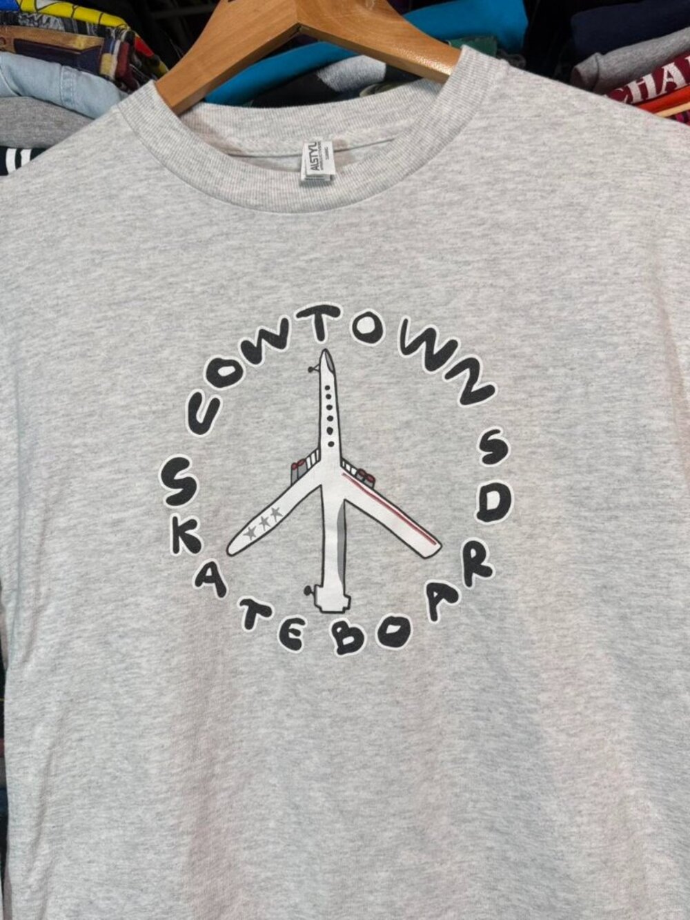Grey long sleeve cowtown skateboard shop shirt with peace plane graphic